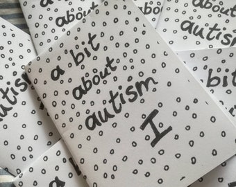 Puede incluir: Una pila de pequeños folletos blancos con lunares negros y el texto "a bit about autism" en la portada.