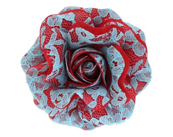 May include: A red and blue lace rose flower. The rose is made of fabric and has a delicate, layered design.