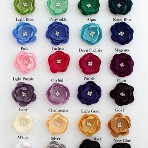 May include: A collection of 24 fabric flower embellishments in various colors, including red, yellow, orange, turquoise, light green, mint, green, teal, light blue, periwinkle, aqua, royal blue, pink, fuchsia, deep fuchsia, magenta, light purple, orchid, purple, plum, ivory, champagne, light gold, gold, white, silver, black, navy blue, peach, coral, burgundy, and brown. Each flower has a pearl center.