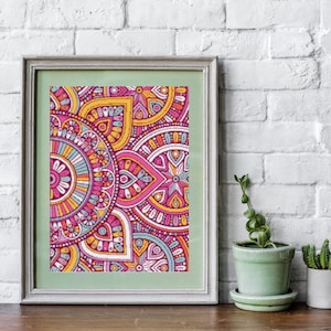 May include: A framed print with a colorful mandala design featuring pink, yellow, blue, and white geometric patterns.