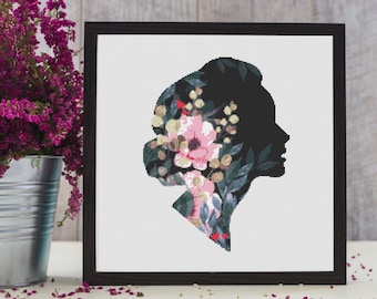 May include: Black silhouette of a person's head with floral designs in shades of pink, green, and white.