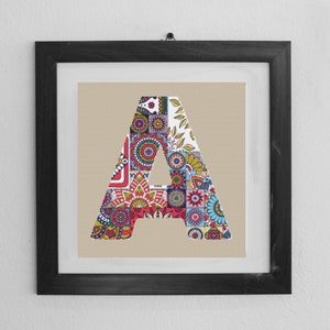 Könnte beinhalten: Ein gerahmter Druck des Buchstabens A, zusammengesetzt aus bunten, gemusterten Quadraten und Kreisen. Der Buchstabe befindet sich in einem schwarzen Rahmen mit einer weißen Passepartout.