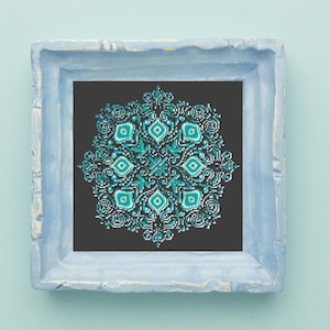 May include: A framed cross-stitch design featuring a teal and green mandala pattern on a black background. The frame is light blue.