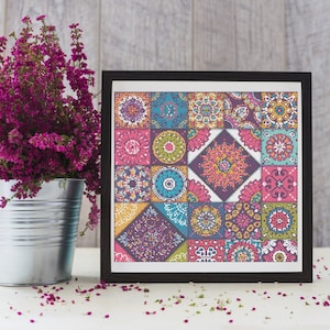 May include: A framed cross-stitch pattern with a colorful geometric design featuring a variety of shapes and colors, including pink, blue, green, yellow, and purple.