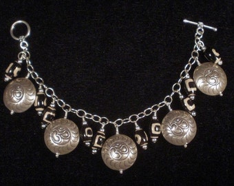 Charm bracelet with the "om" symbol in Hill Tribe silver with etched agate Dzi beads