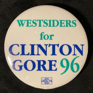 May include: A white campaign button with the text "WESTSIDERS for CLINTON GORE 96" in teal and blue lettering. The button also includes a small logo for Local 714 Union.