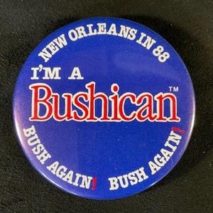 May include: A blue and white button with the text "I'm a Bushican" in red letters. The button also says "New Orleans in 88" and "Bush Again!" in white letters.