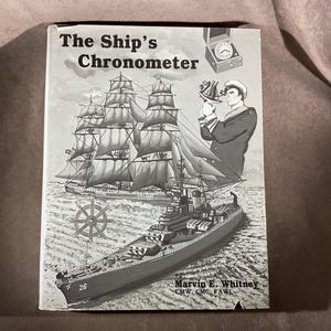 May include: A vintage book titled "The Ship's Chronometer" with illustrations of sailing ships, a naval officer using a sextant, and a ship's wheel. The cover is in black and white, with the author's name at the bottom.