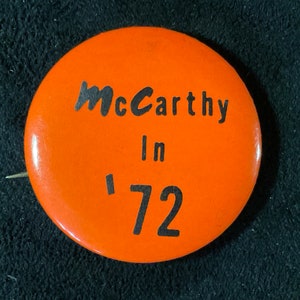 May include: Orange button with black text that reads "McCarthy In '72".