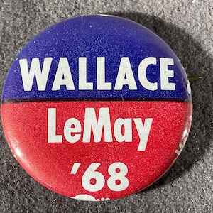 May include: A round political campaign button with a blue upper half and a red lower half. The white text reads "WALLACE" above "LeMay" and the year "'68".