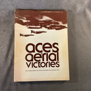 May include: A book titled "Aces & Aerial Victories" with a brown cover and a photo of fighter jets on the front. The book's subtitle is "The United States Air Force in Southeast Asia 1965-1973".