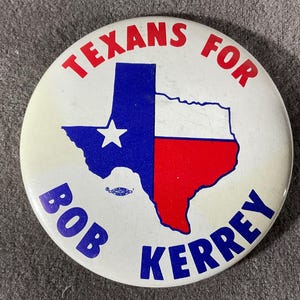 May include: A round, white button with the words "TEXANS FOR" in red at the top and "BOB KERREY" in blue at the bottom. The center features a blue, white, and red outline of the state of Texas.