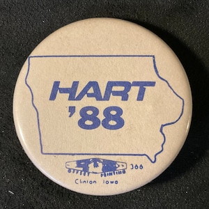 May include: A tan button with a blue outline of the state of Iowa. The text "HART '88" is printed in blue on the button. The bottom of the button has the text "OFFSET PRINTING 366 Clinton Iowa" in blue.