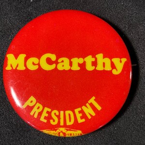 May include: A red and yellow button with the text "McCarthy PRESIDENT" on it.