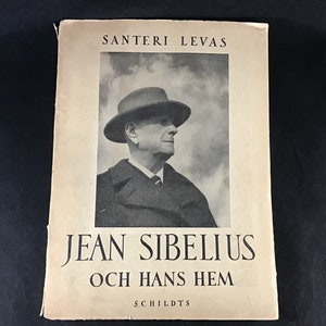 May include: A black and white photo of Jean Sibelius, a Finnish composer, on the cover of a book titled "Jean Sibelius och Hans Hem" by Santeri Levas. The book is published by Schildts.