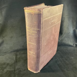May include: A vintage, hardcover book with a dark purple cover. The book's spine displays gold lettering that reads "Messages and Papers of the Presidents 1789-1897". The book is Volume IX, 1890-1897, by Richardson.