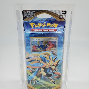 May include: A sealed Pokemon Trading Card Game booster pack featuring a blue and gold design with an illustration of Zacian, a legendary Pokemon with a sword and a blue and white mane. The pack is labeled "Play This Deck Online" and has a 6+ age rating.