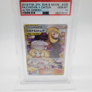 Puede incluir: Una carta de comercio de Pok&eacute;mon con Cynthia y Caitlin de la serie Sol y Luna. La carta est&aacute; calificada como Gem Mint 10 por PSA. La carta es una carta de Entrenador y es una carta de Equipo de Etiqueta. La carta es del set Alter Genesis.
