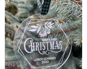 Puede incluir: Adorno redondo transparente con un diseño geométrico y el texto "Baby's First Christmas Leroy Edward 2020".