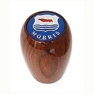 May include: A wooden gear shift knob with a blue and white Morris logo featuring a red cow and the word "MORRIS" in white letters.