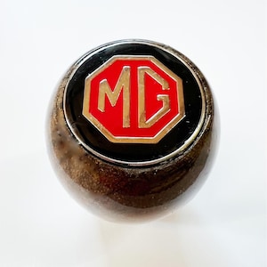 Handgjord växelspaksknopp i valnöt med emaljerad logotyp för MG Midget 1962-1979