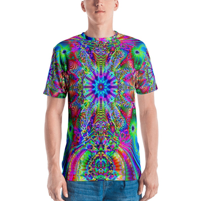 Puede incluir: Una camiseta psicod&eacute;lica con un patr&oacute;n de espiral colorido. El dise&ntilde;o presenta una estrella central con un centro azul y l&iacute;neas radiales de rosa, amarillo, verde y rojo.