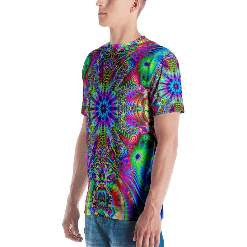 Puede incluir: Una camiseta de manga corta con un patr&oacute;n psicod&eacute;lico en tonos azules, verdes, rosas y amarillos. El patr&oacute;n presenta un dise&ntilde;o de remolino caleidosc&oacute;pico.