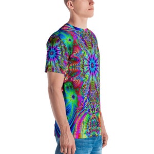 Puede incluir: Una camiseta de manga corta con un patr&oacute;n psicod&eacute;lico en tonos de azul, verde, rosa y rojo. El patr&oacute;n presenta formas giratorias y estrellas.