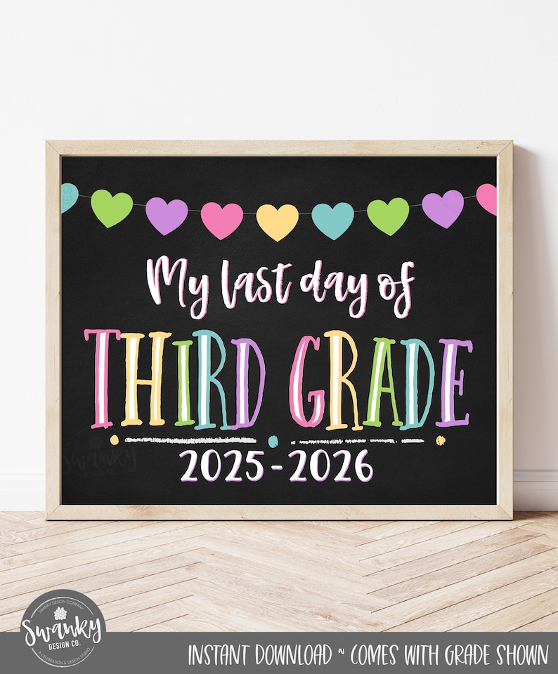 May include: A framed chalkboard sign with the text "My last day of THIRD GRADE 2025-2026." The sign has a wooden frame and a garland of colorful hearts across the top. The words are in white and rainbow colors.