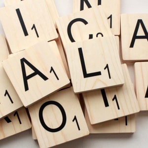 May include: A close-up of wooden letter tiles with black lettering. The tiles spell out the word "ANALOG" with the letter "O" being the only tile not visible in the image. Each tile has a number "1" printed on it.