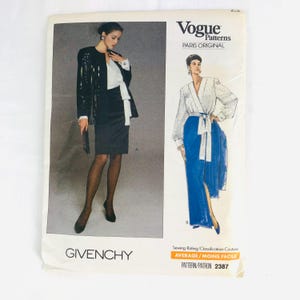 May include: Vintage Vogue Patterns sewing pattern for a Givenchy design. The pattern is for a black skirt suit and a blue wrap dress. The pattern number is 2387 and the sewing rating is average.