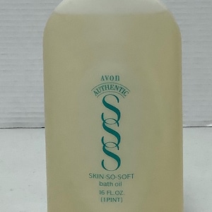 May include: A beige Avon Skin-So-Soft bath oil bottle with a teal cap. The bottle has the text "AVON AUTHENTIC" and "SKIN-SO-SOFT bath oil 16 FL.OZ. (1 PINT)".