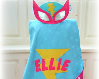 Turquoise, pink, yellow lightning bolt superhero set cape, mask and cuffs