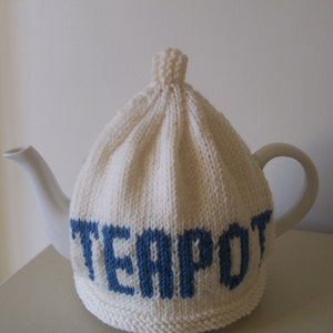 Puede incluir: Cobertor de tetera de punto blanco con letras azules que dicen "TEAPOT".