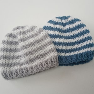 May include: Two knitted hats with white and grey stripes and white and blue stripes.
