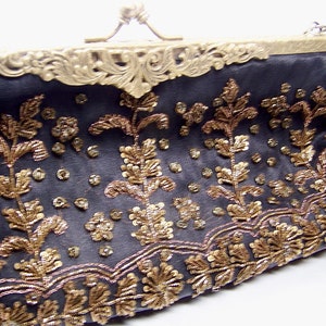 C) oblong clutch or handle bag, brass frame exstensive beading on front only, satin fabric, mirror inside and beaded chain handle.