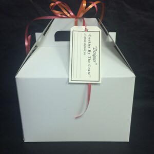 May include: White gift box with a red ribbon and a tag that says "Designer" Cookies By The Crate. A special shipment for...