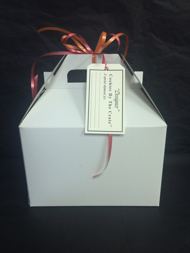 May include: White gift box with a red ribbon and a tag that says "Designer" Cookies By The Crate. A special shipment for...