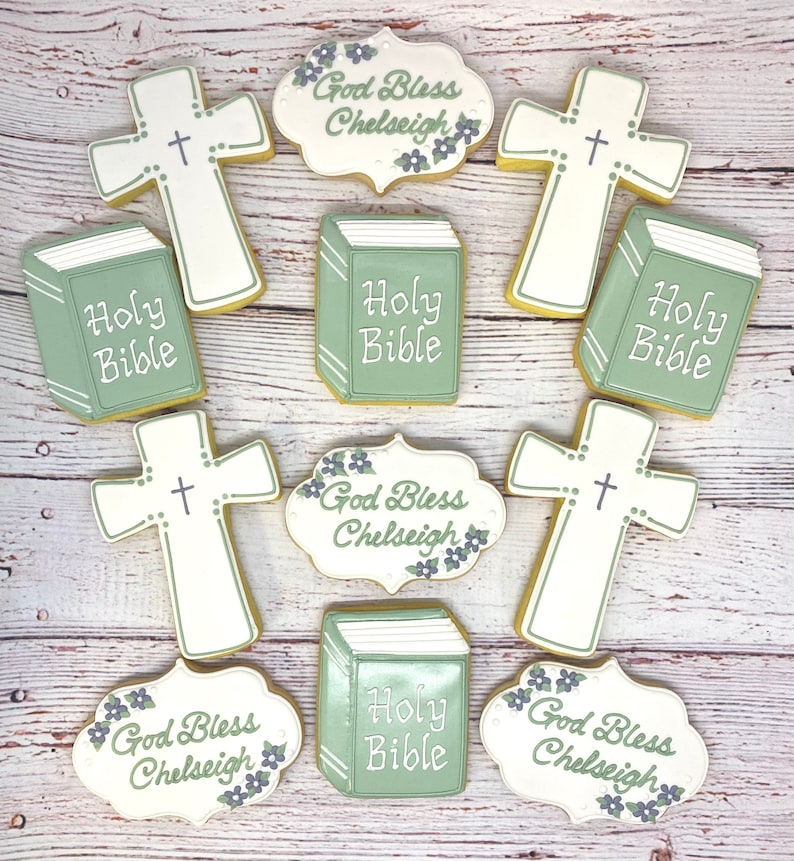 May include: Nine decorated sugar cookies with religious themes. The cookies are decorated with green and white icing and feature images of crosses, Bibles, and the text "God Bless Chelseigh" and "Holy Bible".