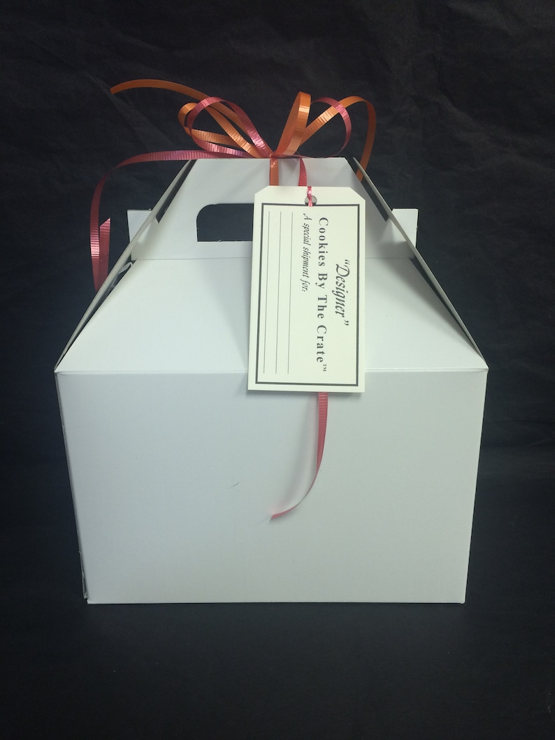May include: White gift box with a red ribbon and a tag that says "Designer" Cookies By The Crate. A special shipment for...