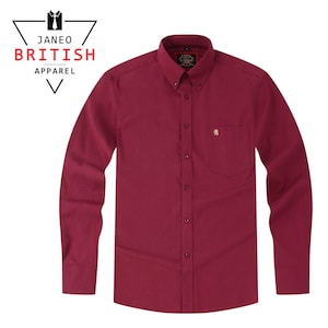 May include: A long-sleeved, button-down shirt in a rich burgundy hue. The shirt has a button-down collar, a chest pocket, and a small embroidered lion emblem. The text "JANEO BRITISH APPAREL" is visible in the upper left corner.