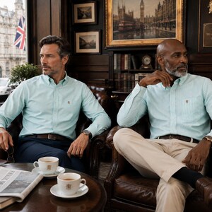 Puede incluir: Dos camisas de manga larga con botones en color verde menta claro, una lisa y otra con finas rayas verticales blancas. Ambas camisas presentan un peque&ntilde;o escudo bordado en el bolsillo izquierdo del pecho, cuello cl&aacute;sico y pu&ntilde;os abotonados.
