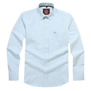 Puede incluir: Una camisa de manga larga con botones y un patr&oacute;n de rayas verticales en azul claro y blanco. La camisa incluye un cuello abotonado, un bolsillo en el pecho con un peque&ntilde;o emblema de le&oacute;n dorado y una etiqueta roja y negra en el cuello.