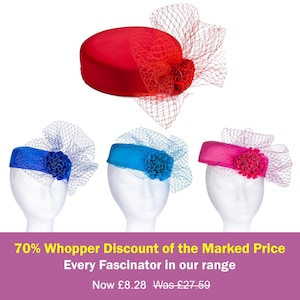 May include: Four pillbox-style fascinator hats in red, royal blue, turquoise, and hot pink. Each hat features a matching fabric flower and a decorative netting veil. The hats are displayed on white mannequin heads against a plain background.
