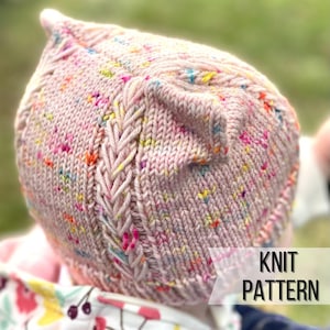 Puede incluir: Un gorro de punto rosa con un patrón moteado de colores y un detalle trenzado. El gorro tiene una parte superior puntiaguda y un borde doblado. El texto "KNIT PATTERN" es visible en la esquina inferior derecha de la imagen.
