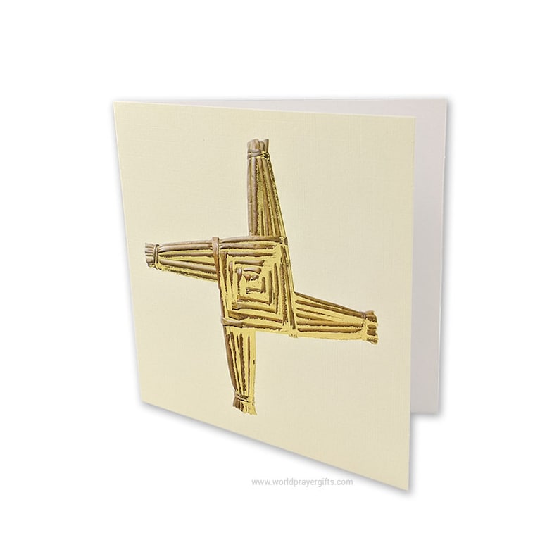 May include: A gold Celtic cross card with a white background. The cross is made of woven straw and has a gold metallic finish. The card has the website "worldprayergifts.com" printed on the bottom.