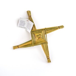 May include: A woven straw Celtic cross, also known as a St. Brigid's cross, with a small tag attached that reads "Generations of generations have brought this cross to the world with the reverence of faith and the ancient traditions of the people of Ireland. worldprayergifts.com".