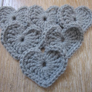 Peut inclure: Un triangle crocheté gris composé de plusieurs cercles reliés.