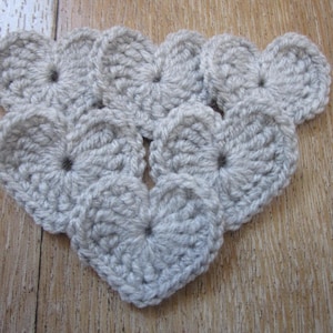 Peut inclure: Une collection de cœurs en crochet gris disposés en forme de triangle.