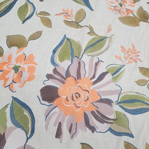 May include: A beige fabric with an embroidered floral pattern. The flowers are in shades of orange, brown, and pink. The leaves are green and blue.